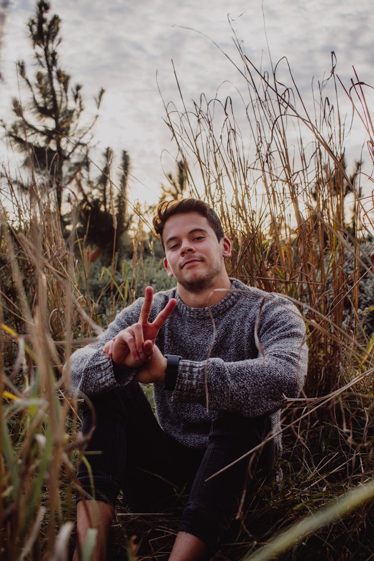 Man Sitting On The Bush Showing Peace Sign