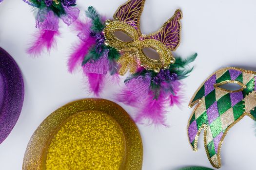 Colorful Mardi Gras masks with feathers and glitter displayed on a white background.