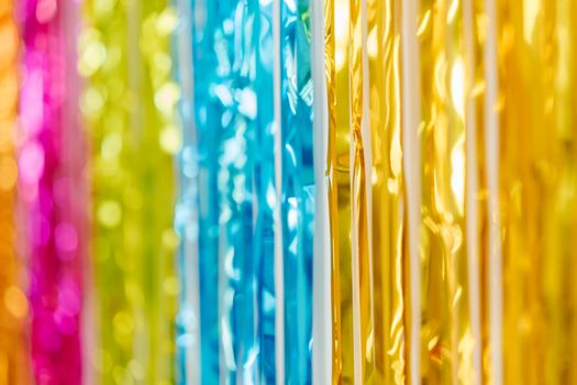Colorful foil curtain creating a lively party atmosphere with a mix of vibrant yellow, blue, and pink hues.