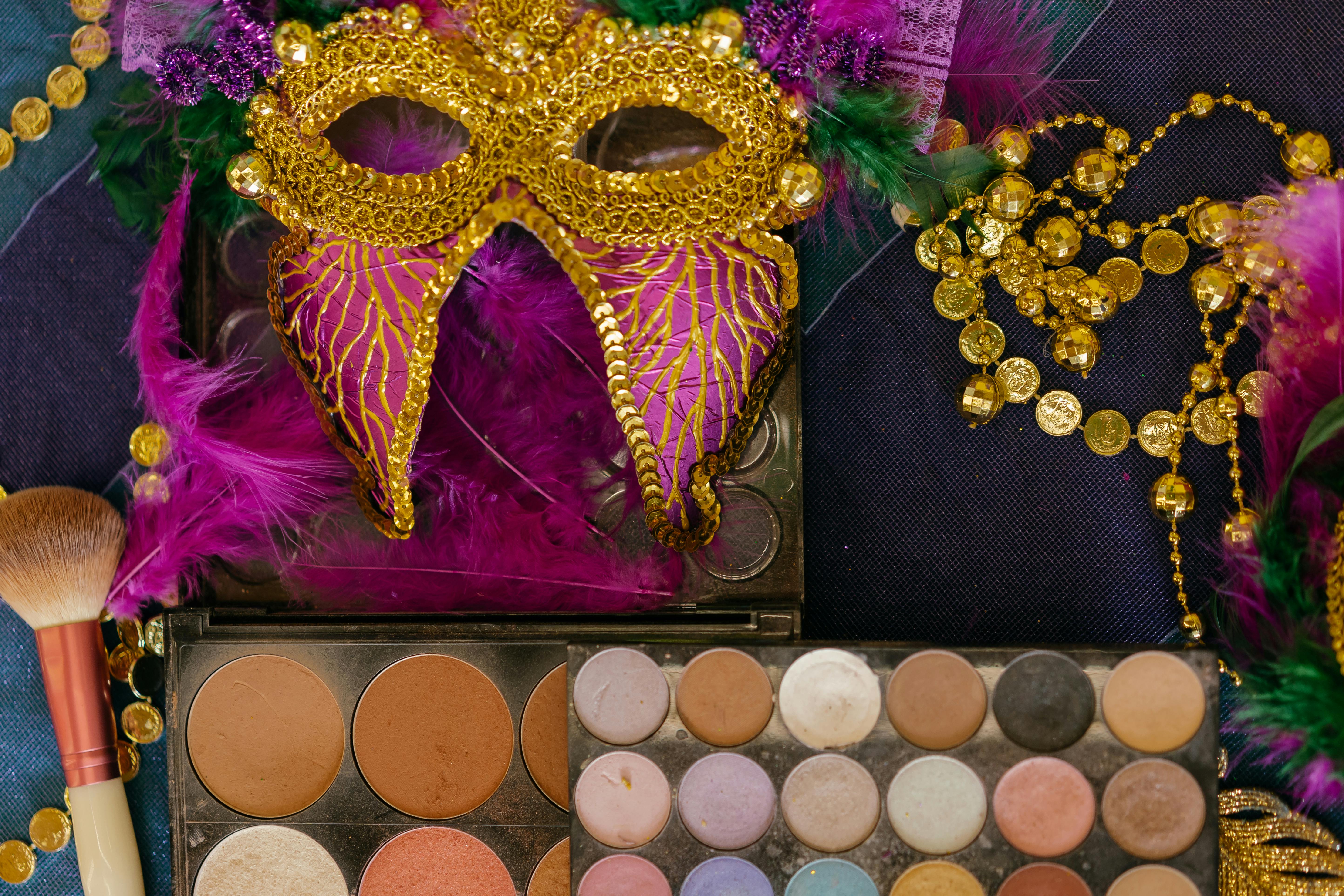 purple masquerade mask beside a makeup set