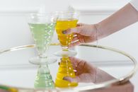 Person Holding Clear Glass Cup With Yellow Liquid