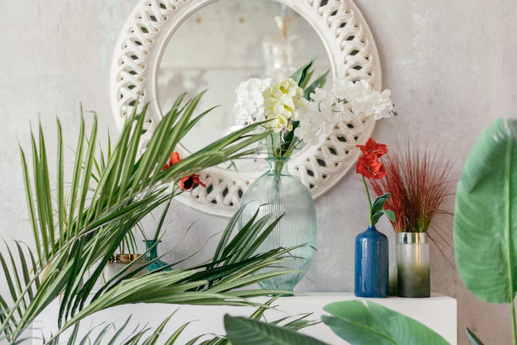 Flower Vases In Front Of A Wall Mirror