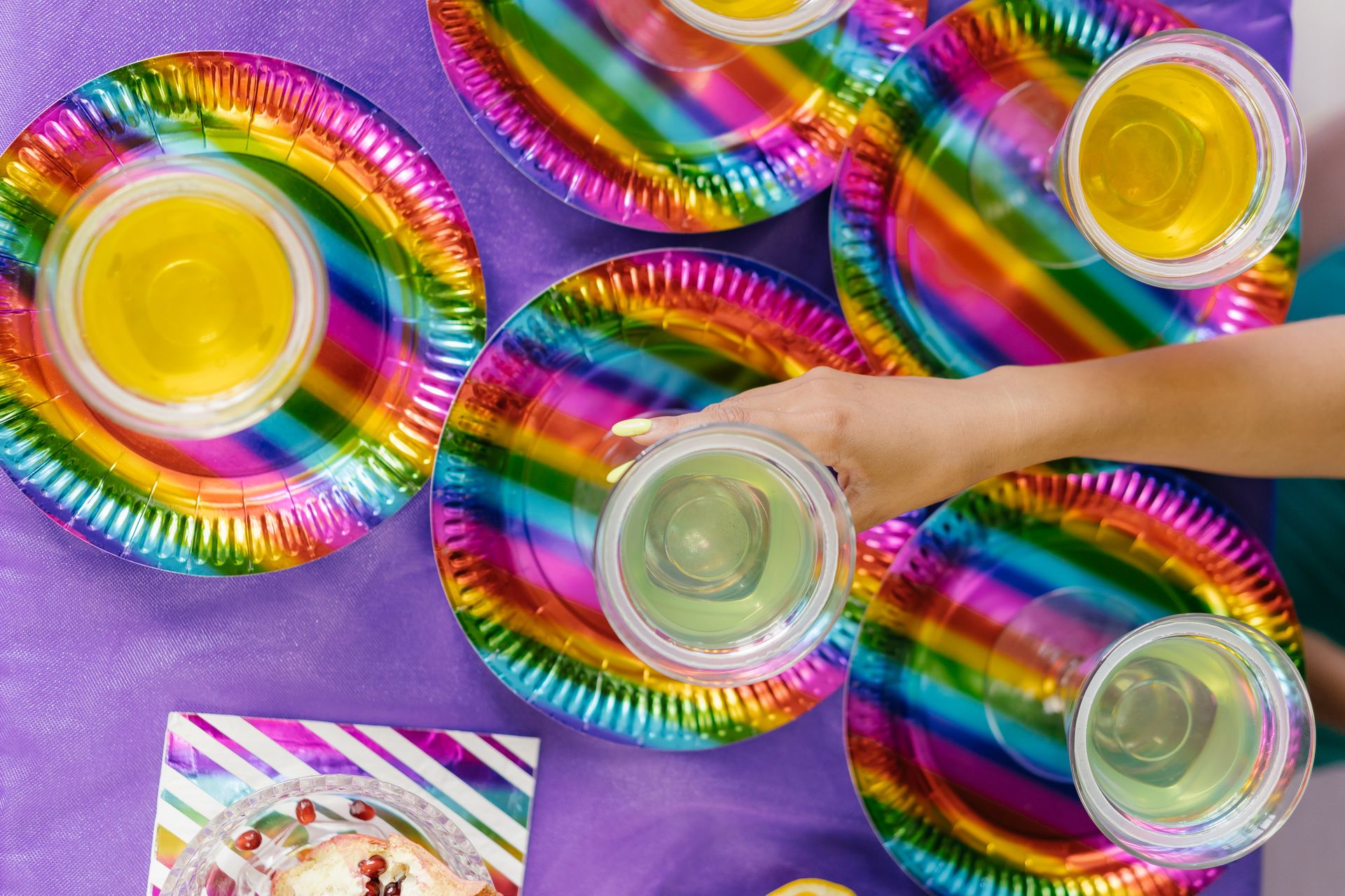A top view of colorful plates and drinks at a party, showcasing vibrant party decor.