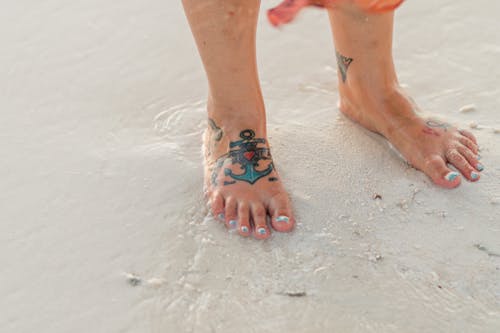 A Person Barefooted on the Beach Sand