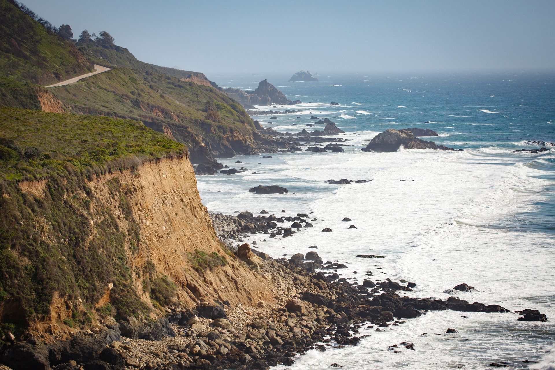 Breathtaking view of scenic Cambria cliffs with waves crashing against the rocky coast.