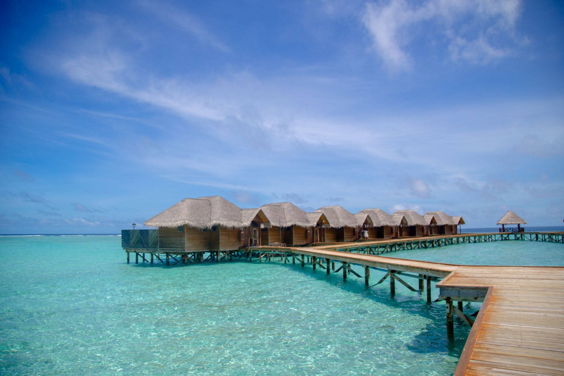 turquoise lagoon with overwater villas and palm trees