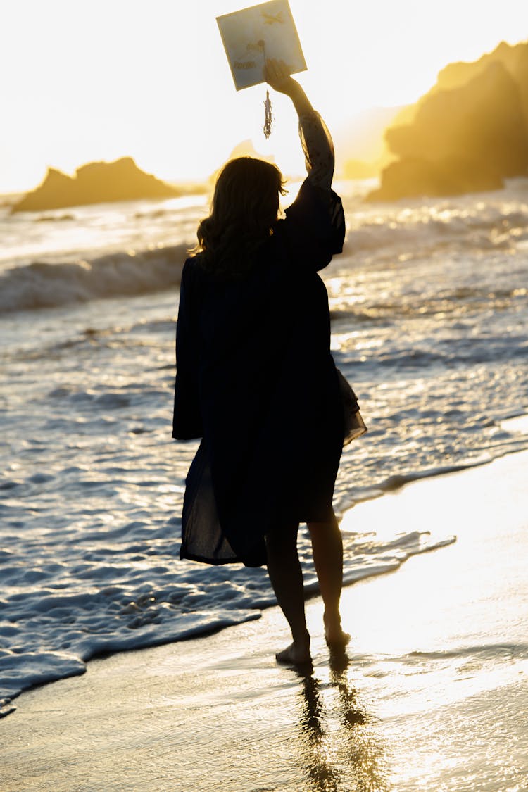 Silhouette Of A Woman Holding A Mortarboard