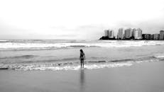 在巴西博凯朗宁静的海滩上，一个人影孤零零地站在海边