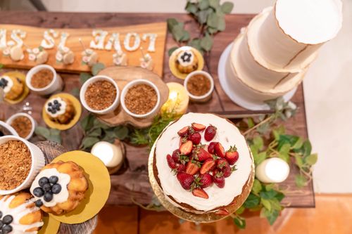 Free Top view of a wedding dessert table featuring a styled cake with strawberries and assorted pastries. Stock Photo