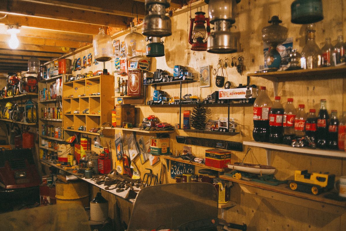 Workshop shelves packed with vintage hardware, jars, and tools