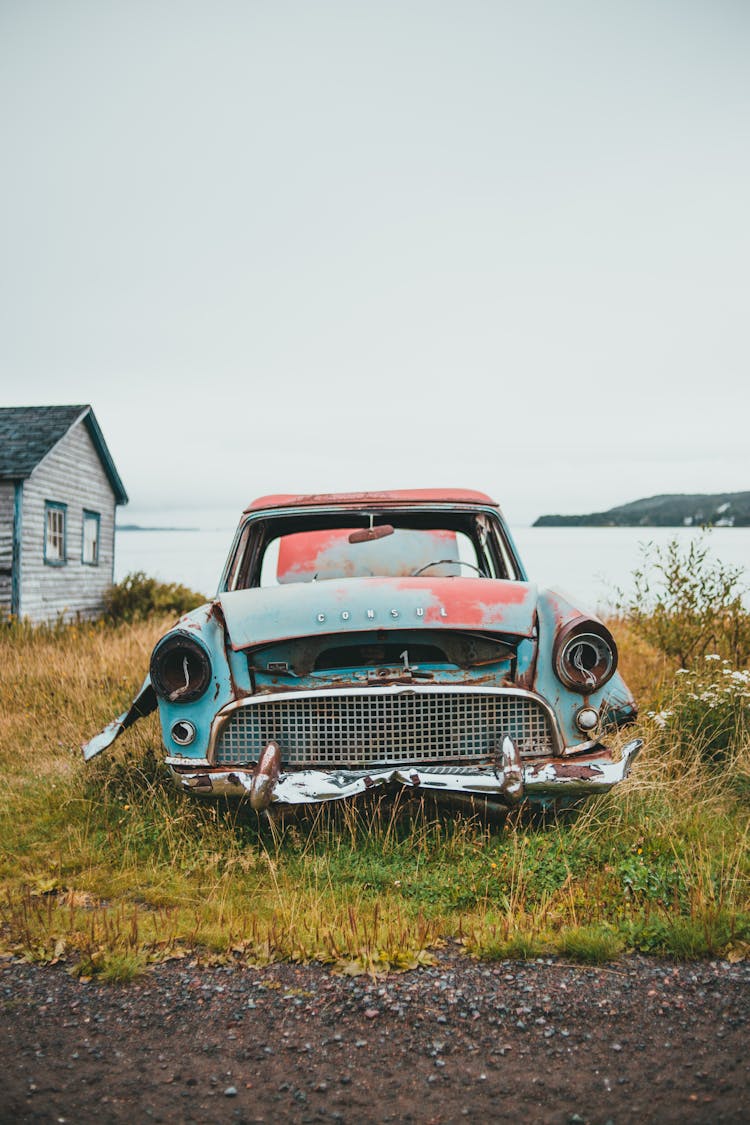 Rusted Car Remains In Grass Field