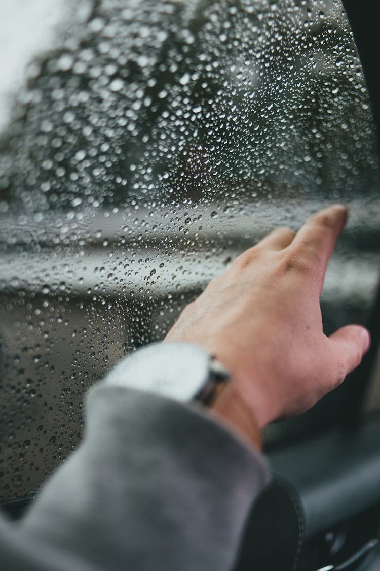 Hand Touching A Wet Car Window