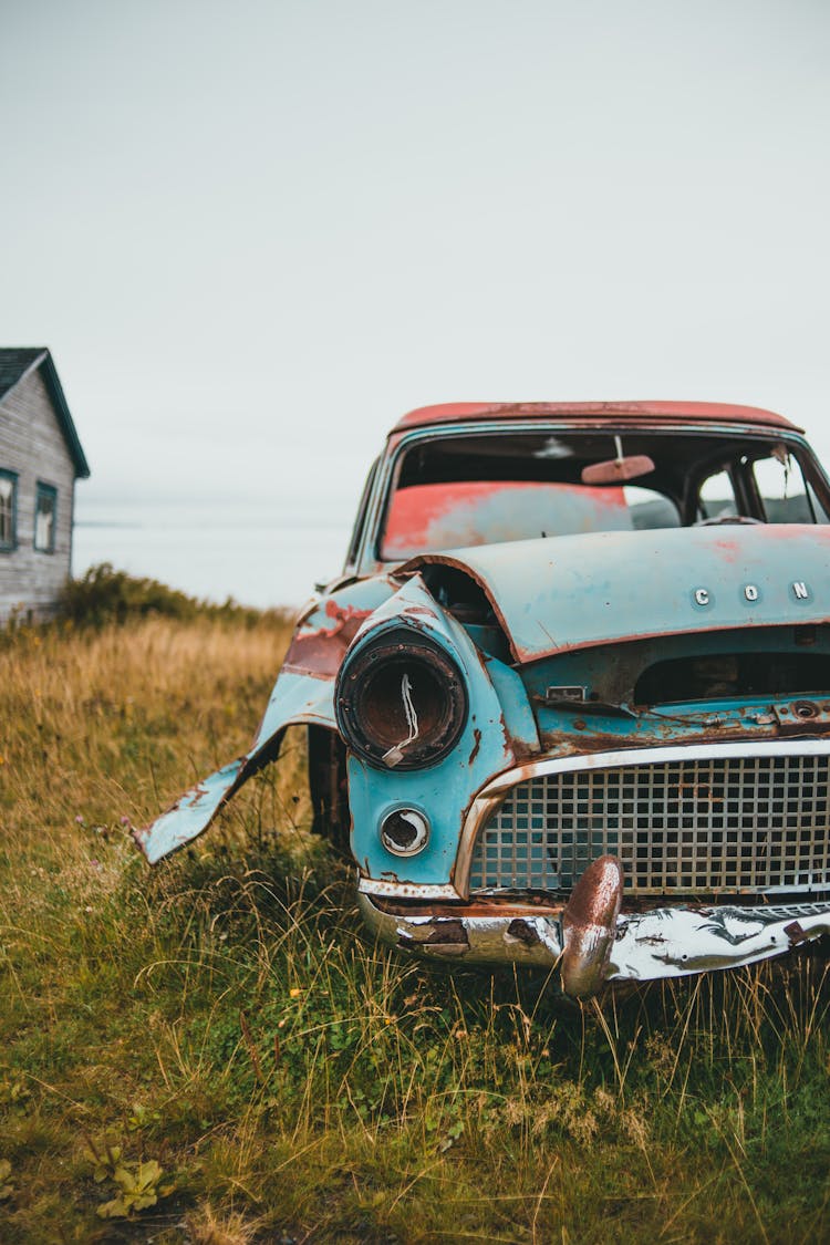 Wrecked Abandoned Car On A Grass Field