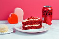 A Slice of Cake on a Ceramic Plate and a Can of Coke