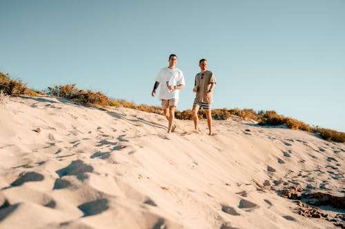Man and Woman Walking on White Sand