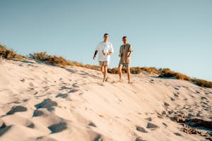 Man and Woman Walking on White Sand
