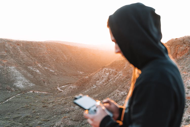 Man With Gadget In Mountain Canyon