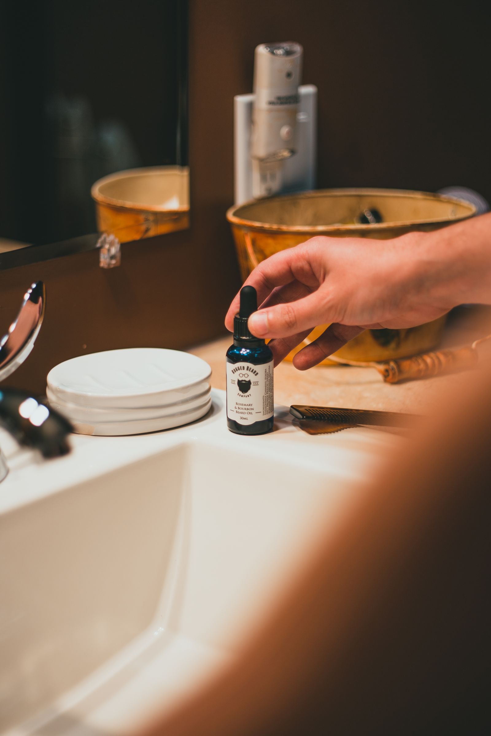 Person holding a dropper bottle beside a sink.