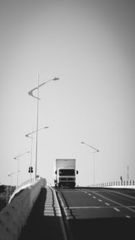 Black and white image of a truck on a São José do Rio Preto bridge, captured in striking monochrome.