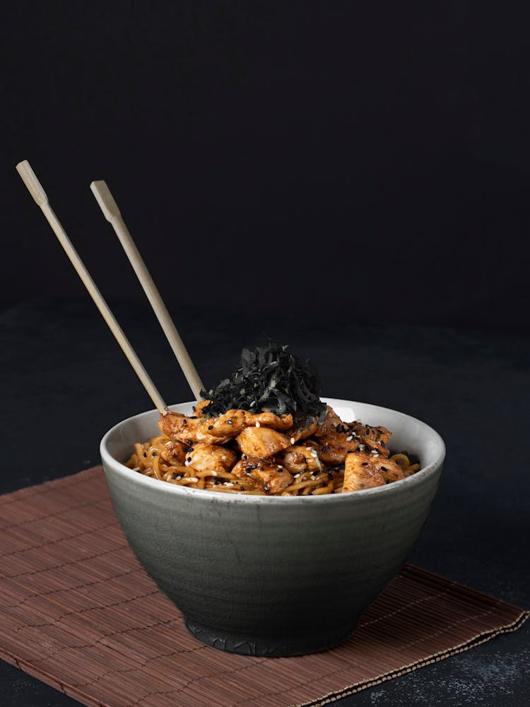 Traditional Asian Dish With Chopsticks On Black Background