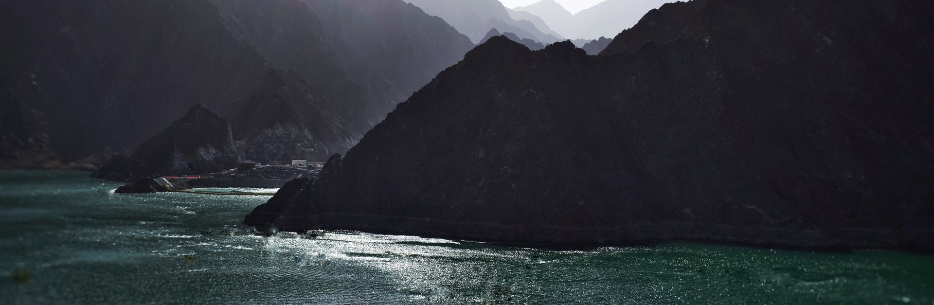 Captivating view of a sunlit lake surrounded by towering mountains, illustrating the beauty of natur