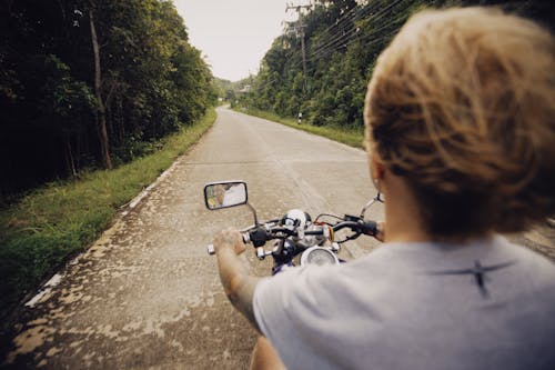 Free A Person in Gray Shirt Riding Motorcycle on Road Stock Photo