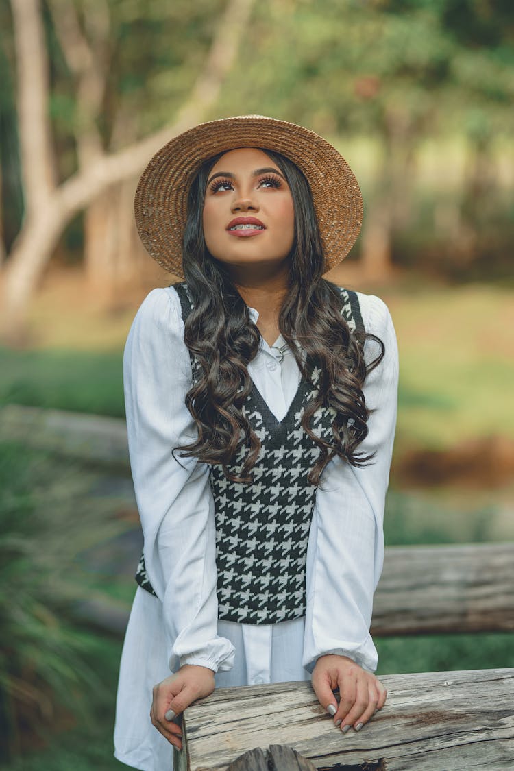 Young Woman In Hat Posing In Park