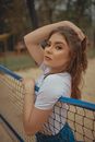 Girl in White T-shirt Leaning on Blue Metal Fence