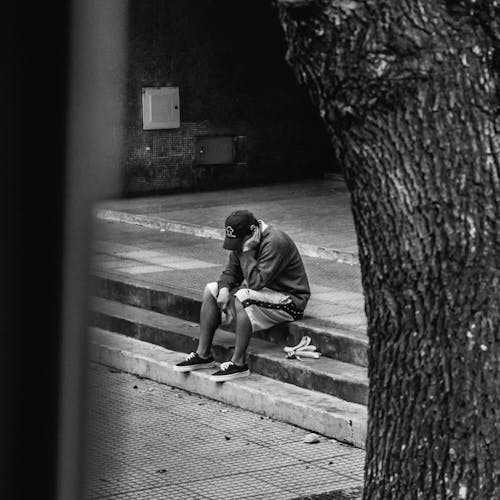 A Person Sitting on the Pavement