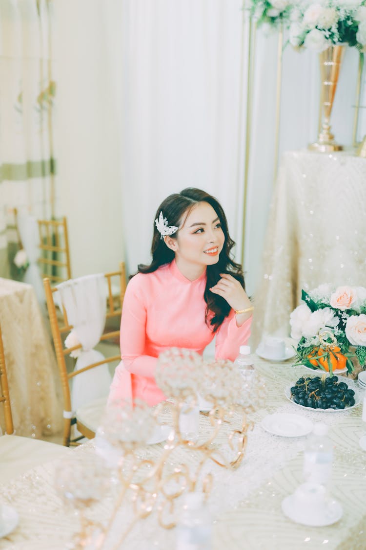 Woman In Dress Sitting At Table At Wedding Celebration