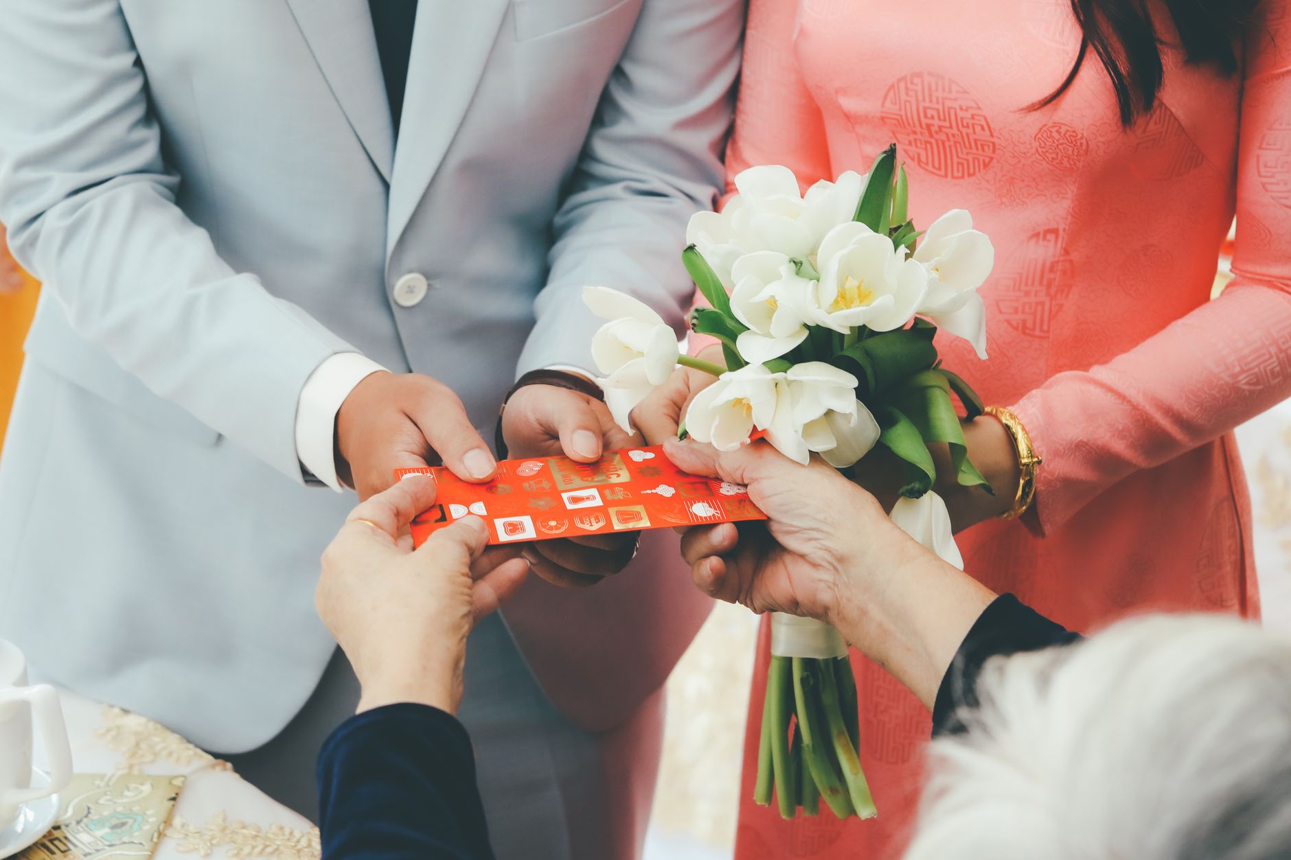 Close-up of a wedding gift exchange with a bouquet, symbolizing love and togetherness.