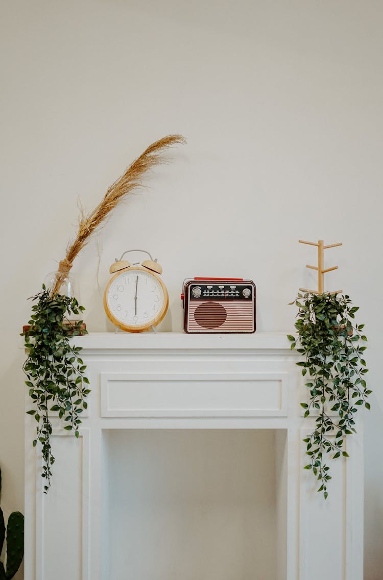 Alarm Clock And Vintage Radio On White Desk