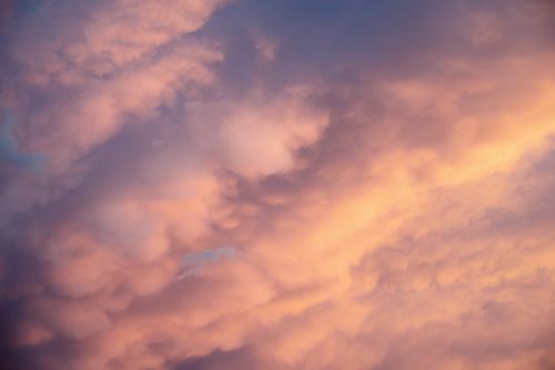 Free A tranquil sky with soft clouds at sunset, featuring pink and orange hues. Stock Photo