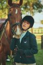 Girl in Black Coat Riding Brown Horse