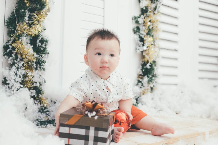 A Baby Boy Holding Gift Box