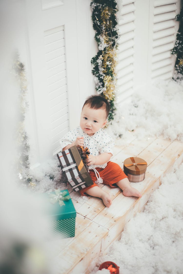 Baby Sitting On Bench Playing With Boxes