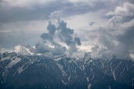 阴沉的天空下，雄伟的山脉飘起了雪，捕捉着冬天的美丽