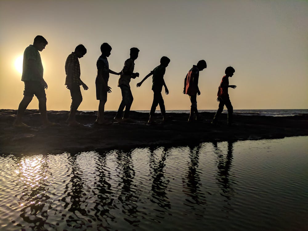 Free Group of Children Walking Near Body of Water Silhouette Photography Stock Photo