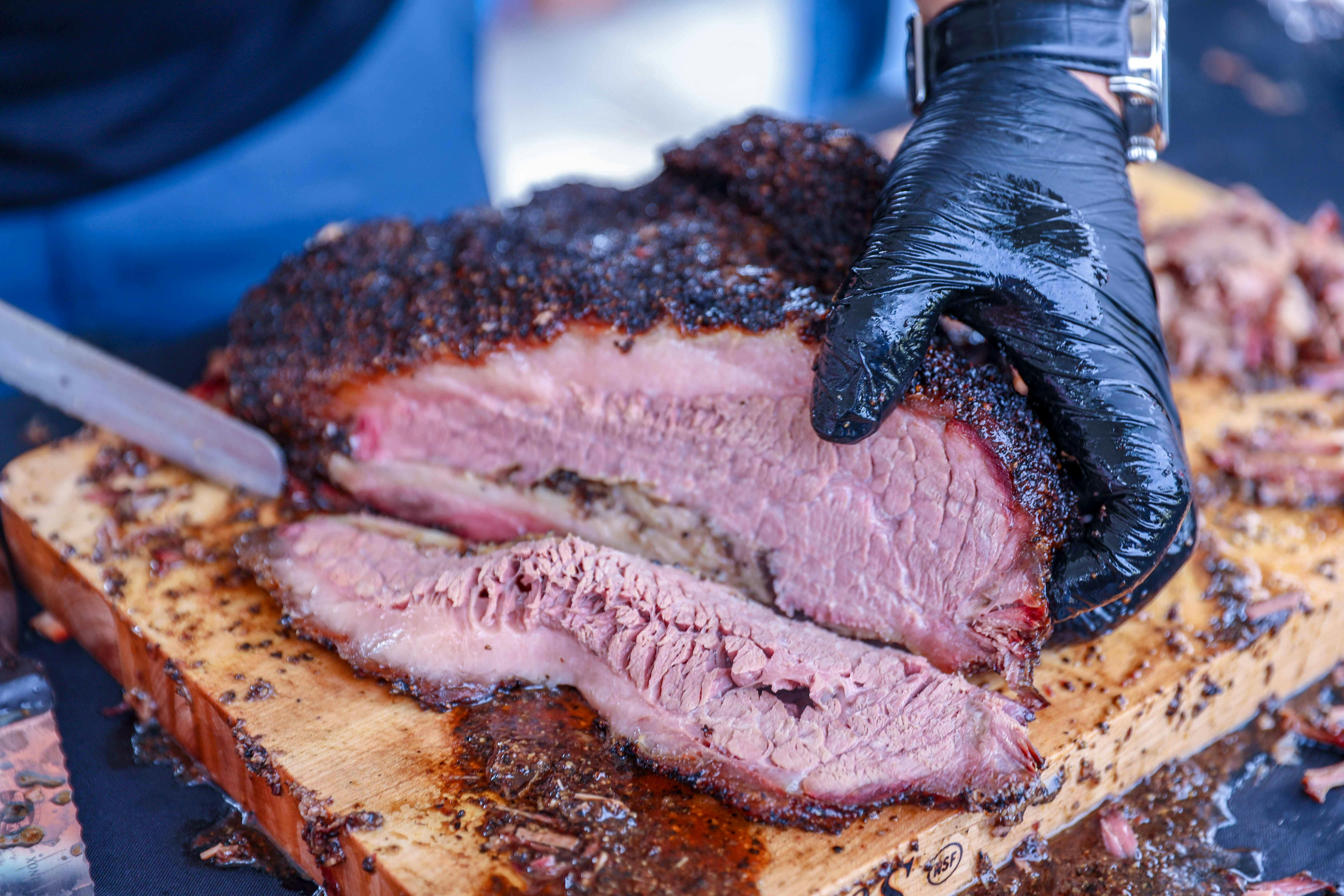 a person slicing barbecue beef brisket