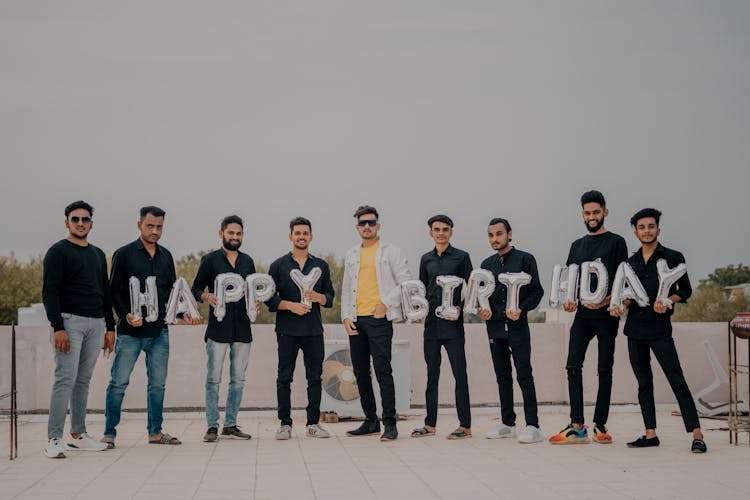 Group Of Men Holding Birthday Balloons