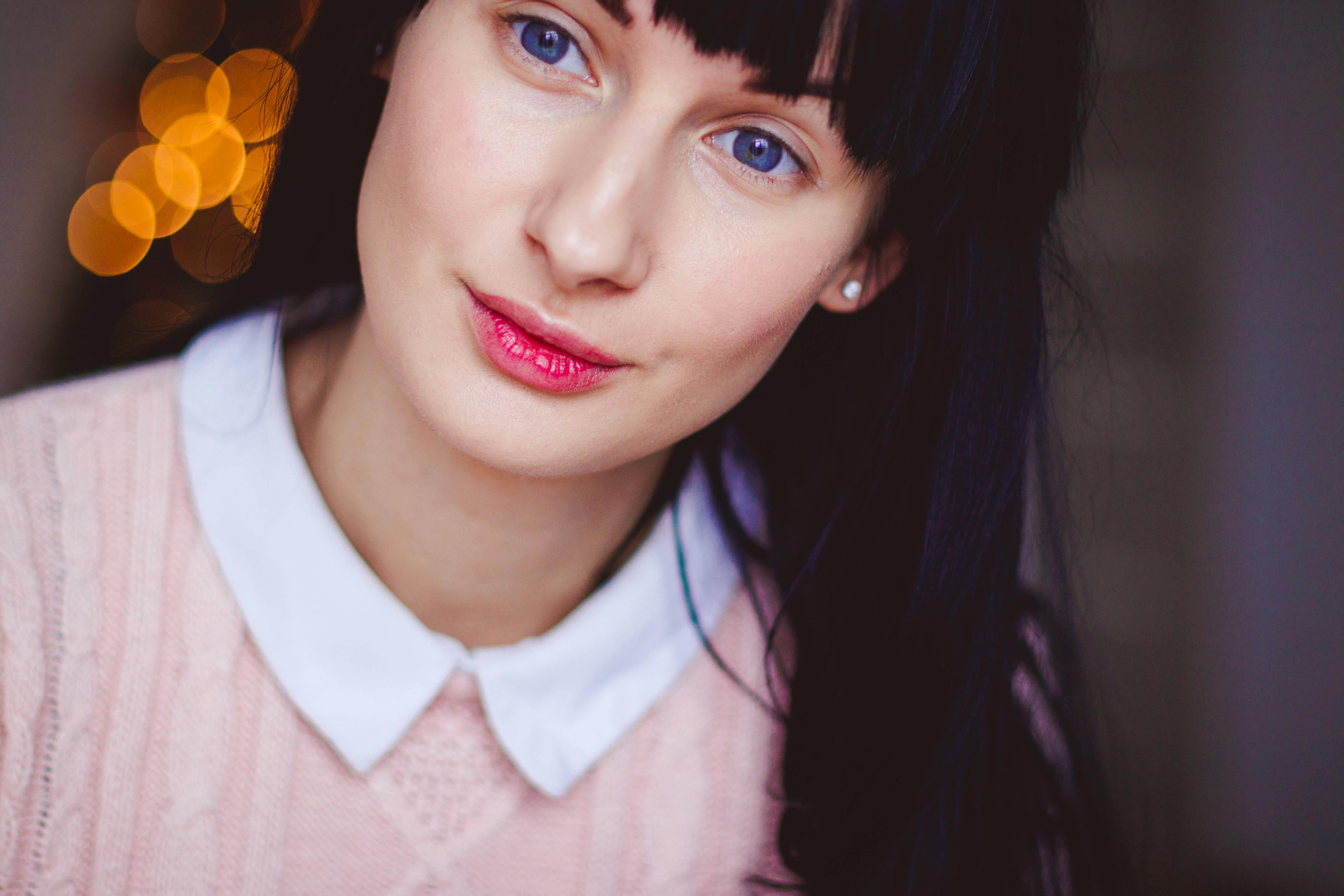 柔和的灯光下，年轻女子的特写肖像展现出精致的五官和优雅的风格