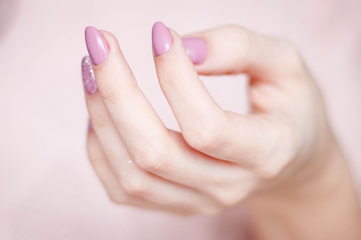 Close-up of a hand with a stylish pink glitter manicure