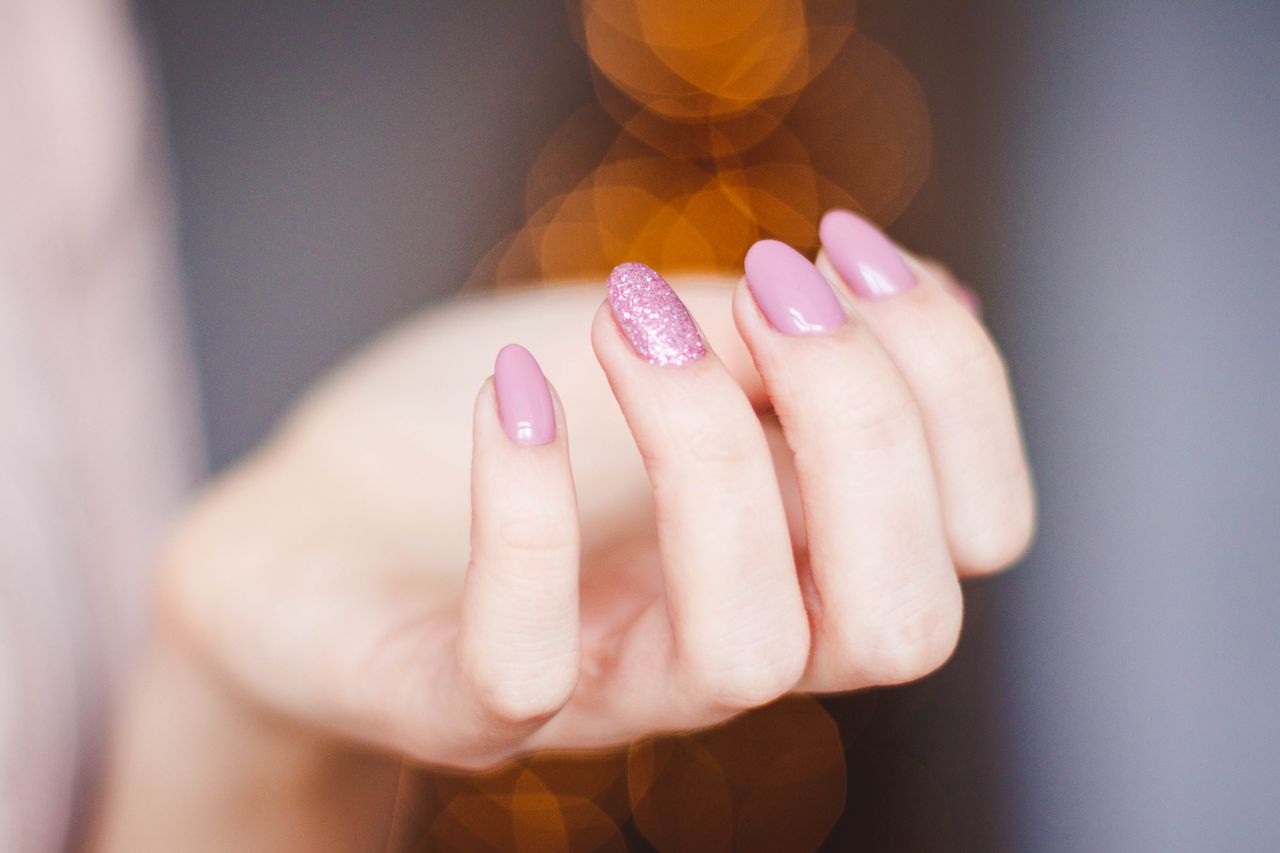 Manos con uñas acrílicas decoradas artísticamente