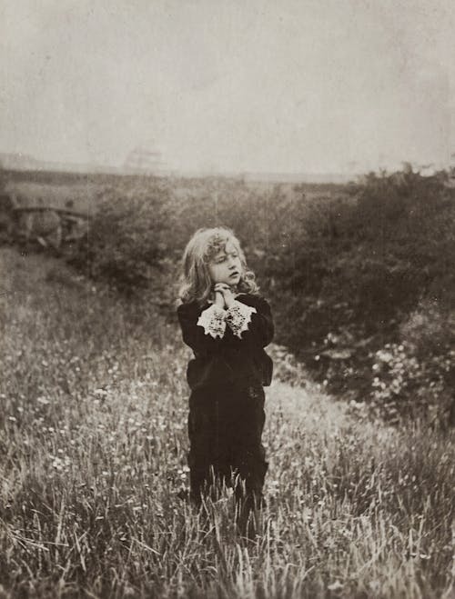 Child Standing on a Grass Field