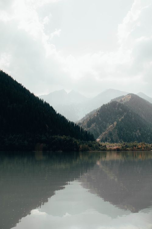 Free Serene mountain lake in Almaty, Kazakhstan, reflecting lush green ridges. Stock Photo