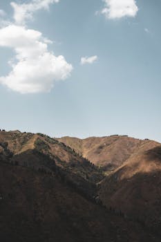 A peaceful view of mountains under a clear blue sky in Almaty, Kazakhstan.