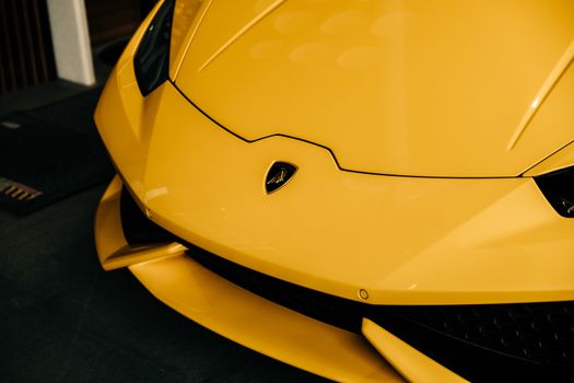 Detailed close-up of a sleek yellow Lamborghini hood with iconic emblem.