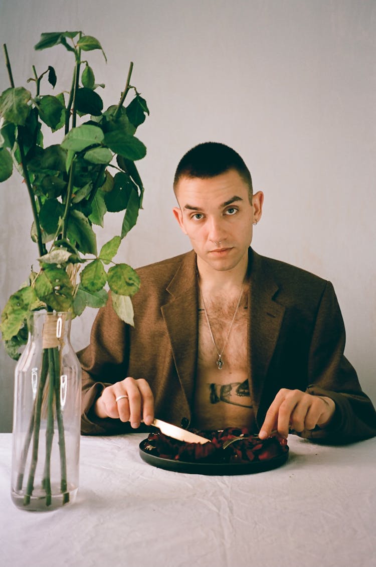 Portrait Of A Young Man Eating At A Table