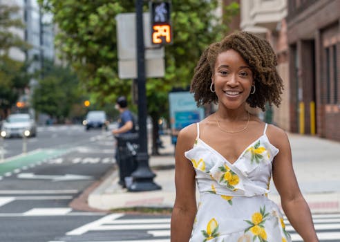 African American woman with afro hair smiling in Washington, DC street scene.