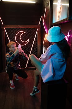 Young adults in modern style capturing a neon-lit moment indoors.